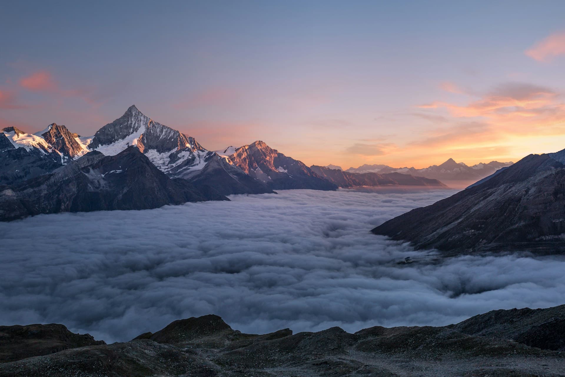Mountain ridges above mist at dawn.